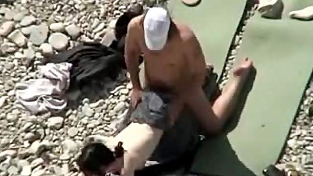 Lewd couple makes love on a nude beach in the presence of their friends
