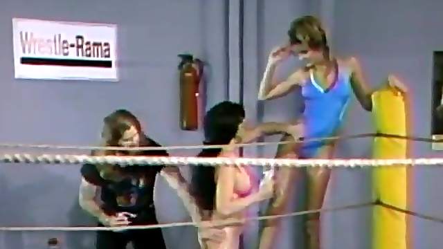 Two lesbians wearing swimsuits fight on a ring in retro clip