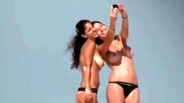Topless amateur brunette babes get caught on voyeur's cam on a beach