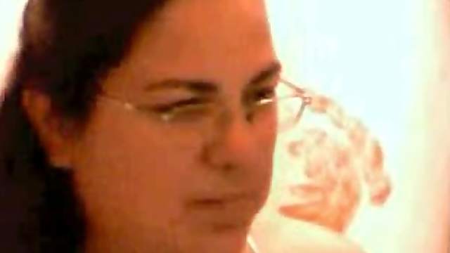 Chubby brunette wearing glasses shows her natural boobs