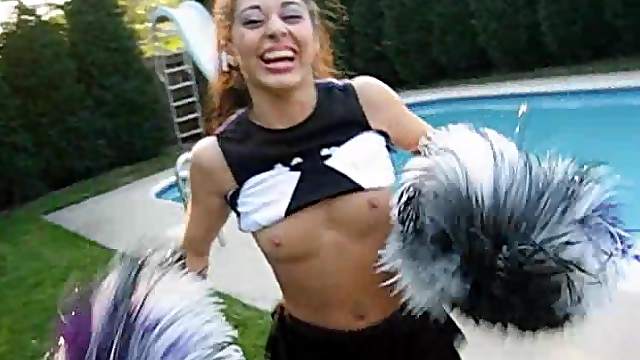 A cute cheerleader flashes her tits while in her uniform