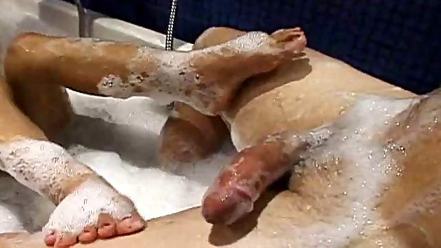 Brunette Asian bitch with natural tits stroking a man in the tub