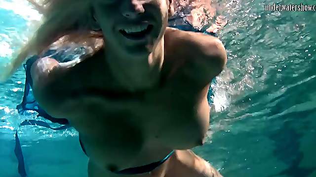 Blonde with natural tits displaying pussy while swimming