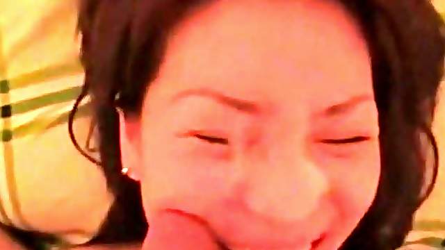 A pretty korean girl is filmed sucking a small cock and taking its cum all over her face
