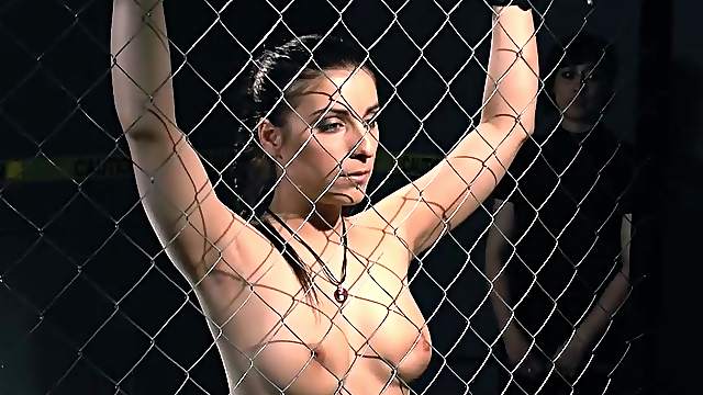 Good looking brunette girl gets tied up to the fence