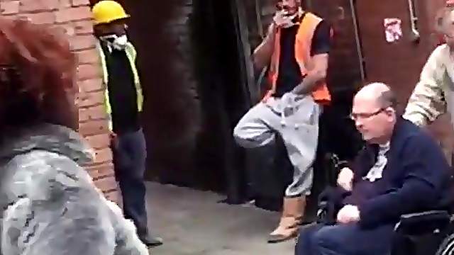 Stranger worker with a hand in his pants tugging on the street