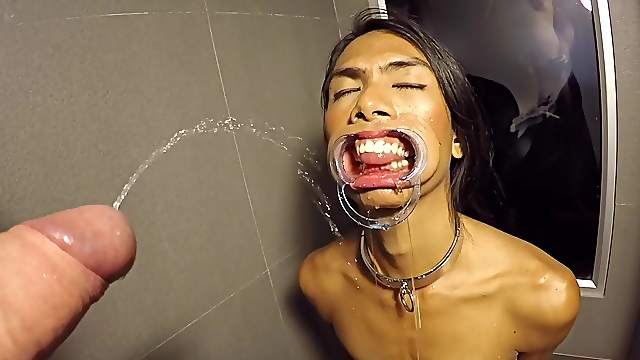 Thai femboy Cat is on the dirty floor of hotel bathroom and looking right on guy's dick in front of her face.