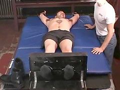 Two older guys having fun tickling a tied up  dude